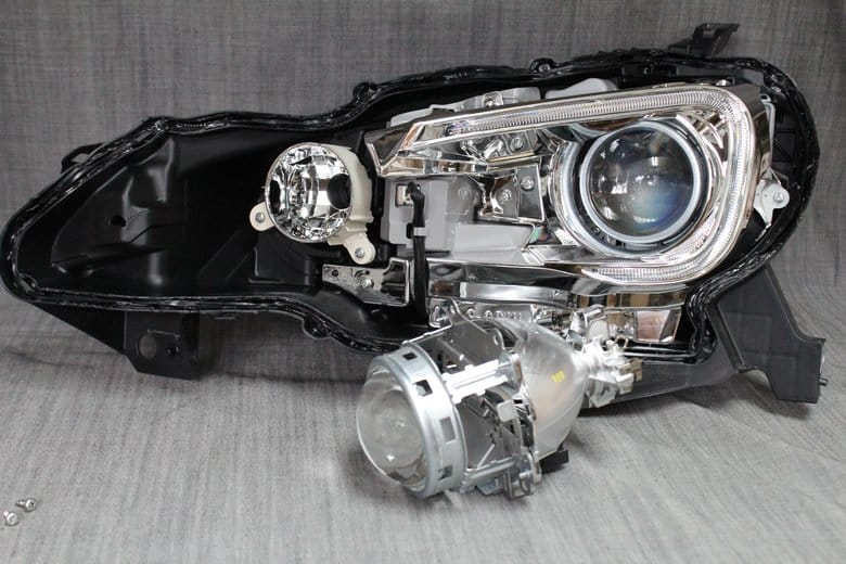 BRZヘッドライト殻割り作業中のプロジェクター交換工程